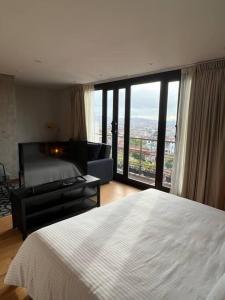 ein Schlafzimmer mit einem weißen Bett und einem großen Fenster in der Unterkunft R3 - Lujoso Loft en la Candelaria in Bogotá