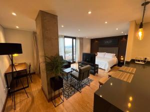 ein Hotelzimmer mit einem Bett und einem Wohnzimmer in der Unterkunft R3 - Lujoso Loft en la Candelaria in Bogotá