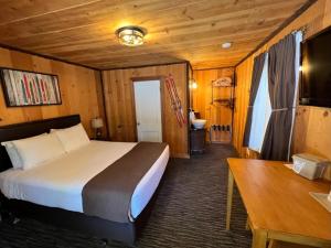 a bedroom with a bed and a table in a room at Shasta Inn in Mount Shasta