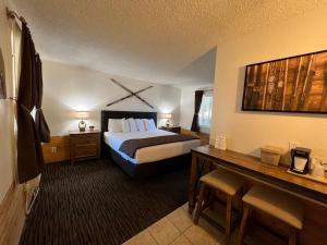 a hotel room with a bed and a desk at Shasta Inn in Mount Shasta