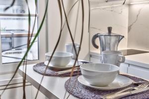 einem Tisch mit zwei Tassen und Tellern auf einer Theke in der Unterkunft Studio Tempa proche du Château de Vincennes - Welkeys in Vincennes