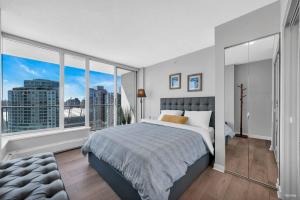 温哥华Spacious DT 2-BDR High-rise with view, pool, gym的一间配有大床和大窗户的卧室 更多8张照片