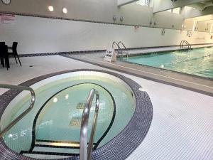 a large swimming pool in a large building at Spacious DT 2-BDR High-rise with view, pool, gym in Vancouver