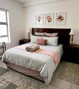 una camera da letto con un grande letto con cuscini rosa e bianchi di The Bridge, Apartment 25 a St Lucia