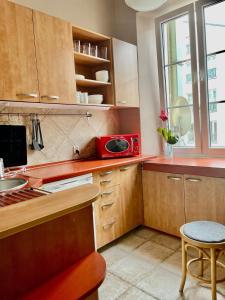 una cucina con forno a microonde rosso su un bancone di BackPack Apart Rooms a Varsavia