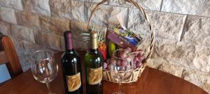 two bottles of wine and a basket of grapes on a table at Casa Tata in Tijarafe