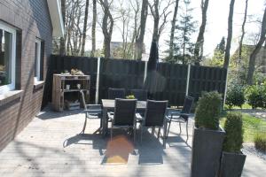 a patio with a table and chairs and a fence at Ferienwohnung Grove in Bippen