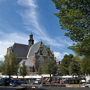 Una gran iglesia con una torre de reloj encima. en The Posthoorn Amsterdam, en Ámsterdam