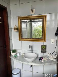 a bathroom with a sink and a mirror at Chalé romântico , rústico e vista de tirar o fôlego in Guaramiranga