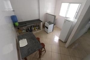 una pequeña cocina con mesa y nevera en Edifício Ferreira - Apartamentos temporadas en Piúma