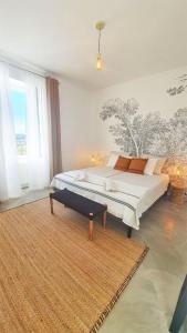a bedroom with a large bed and a rug at Domaine Lapèze in Montcuq
