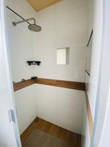 a shower with white tiled walls and a glass door at Increible SUITE A con vista a la Ciudad in Mexico City