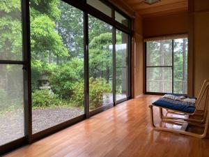 Cette chambre dispose de grandes fenêtres et d'une chaise sur le parquet. dans l'établissement Hourokusha - Vacation STAY 13417, 