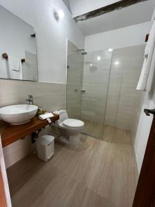 a bathroom with a toilet and a sink and a shower at Hotel Archangelus in Mompós