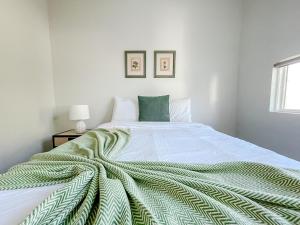 a white bedroom with a green blanket on a bed at Sleepover 1BD 1BA Downtown Bowling Green Apartments in Bowling Green