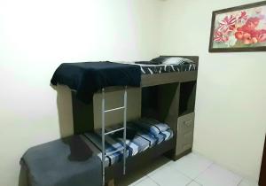 a bunk bed with a ladder in a room at Apto Aeroporto Macae in Macaé