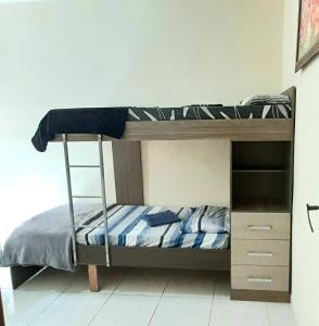 a bunk bed with a ladder in a room at Apto Aeroporto Macae in Macaé