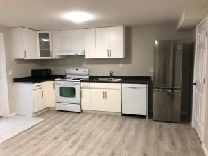 a kitchen with white cabinets and stainless steel appliances at Licensed spacious basement suite with two king size beds in Chilliwack