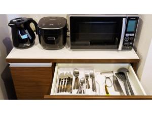 a kitchen counter with a microwave and utensils at Bears Stay Kumejima Eef Beach - Vacation STAY 85672v in Kumejima