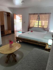 a bedroom with a large bed and a table at Skott's Comfy Lodge in Bantayan Island