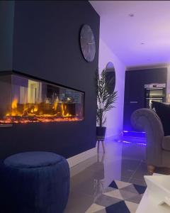 a living room with a fireplace and a clock on a wall at Llanberis Lodges in Llanberis +50 photos