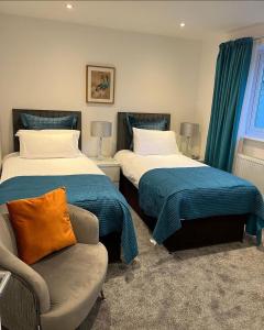 um quarto com 2 camas, uma cadeira e um sofá em Llanberis Lodges em Llanberis