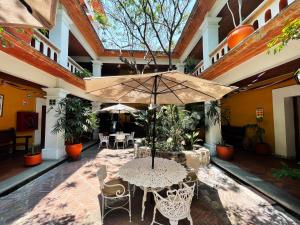 a patio with a table and chairs and an umbrella at Parador del Dominico in Oaxaca City