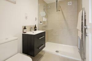 een badkamer met een douche, een wastafel en een toilet bij Seaside Annexe in Felpham