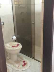 a bathroom with a toilet with a glass shower at Sobrado Lindóia in Curitiba
