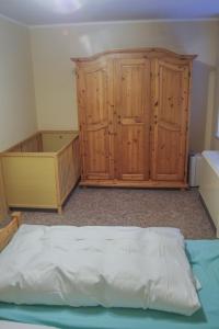 Schlafzimmer mit einem Bett und Holzschränken in der Unterkunft Pension Muldental Großbothen Wohnung 1 in Grimma