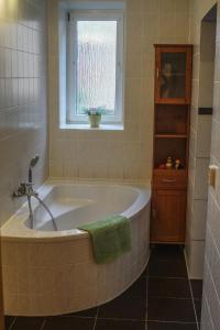 eine Badewanne im Bad mit Fenster in der Unterkunft Pension Muldental Großbothen Wohnung 1 in Grimma
