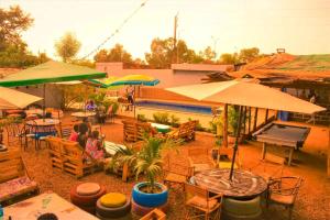 um grupo de pessoas sentadas em mesas com guarda-chuvas em Villa Tenko em Ouagadougou
