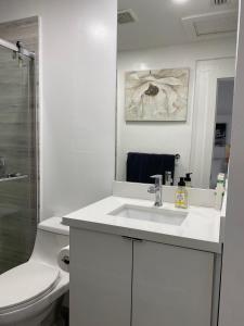 a white bathroom with a sink and a toilet at Modern Home, Excellent Location Miami in Miami