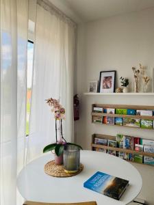 ein Zimmer mit einem Tisch mit einem Buch und Blumen darauf in der Unterkunft Haus am Wasserturm Gästezimmer in Schorndorf-Schlichten in Schorndorf