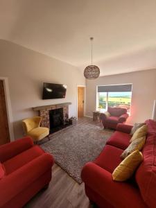 a living room with red couches and a fireplace at Loughinvar, Newtownards in Newtownards