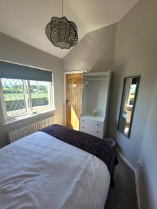 um quarto com uma cama branca e uma janela em Loughinvar, Newtownards em Newtownards