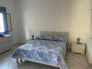 1 dormitorio con 1 cama con edredón azul y blanco en Bilocale a 5 minuti dal mare, en Sciacca