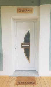 Una puerta blanca con una señal verde de río. en GreenRiver Apartment, en Spodnje Gorje