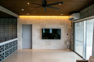 sala de estar con ventilador de techo y TV en la pared en vivid terrace - Vacation STAY 14828v, en Isla Miyako