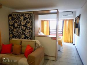 een woonkamer met een bank en een slaapkamer bij Apartamento a Beira Mar - Pipa's Ocean 201 in Pipa