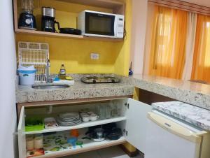een keuken met een wastafel en een magnetron bij Apartamento a Beira Mar - Pipa's Ocean 201 in Pipa