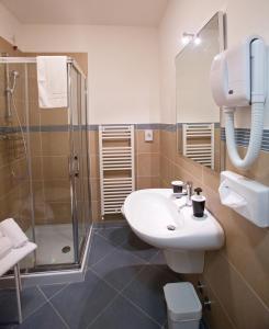 a bathroom with a sink and a shower at Lacroma Aparthotel in Grado