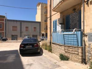 un coche negro aparcado en el lado de una calle en Confortable, en Trapani