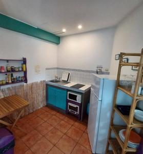 a small kitchen with a stove and a refrigerator at TI coin de paradis Frangipanier in Le Diamant