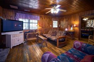 a living room with a couch and a flat screen tv at A Cabin In The Woods in Pigeon Forge