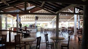 a restaurant with tables and chairs and a room with tables at Hotel Fazenda Hípica Atibaia in Atibaia