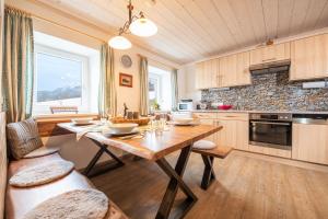 a kitchen with a wooden table and a large window at Ferienhaus Schwöllerbauer in Sankt Martin am Grimming
