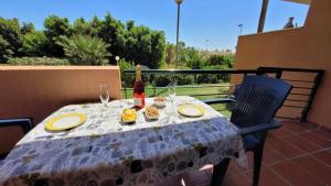 een tafel met een fles wijn en eten op een balkon bij TIMON BEACH HOUSE Playa 70m Piscina Parking in Benalmádena