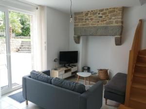 uma sala de estar com um sofá e uma televisão em Maison Jullouville au calme em Jullouville-les-Pins