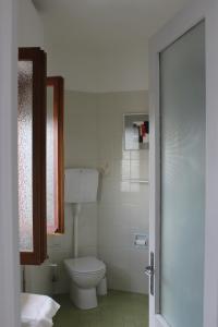 a white bathroom with a toilet and a window at Casa Lia in Lesa +24 photos